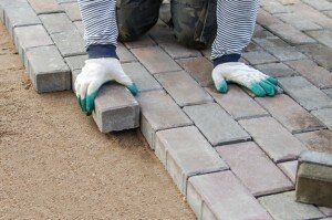 man-paving-stones-on-sidewalk-laying-paving-slabs-in-courtyard-on-leveled-sand-foundation-base_268483-24